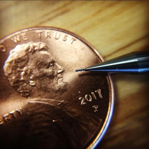 small harvey tool end mill for micromachining on a penny showing size