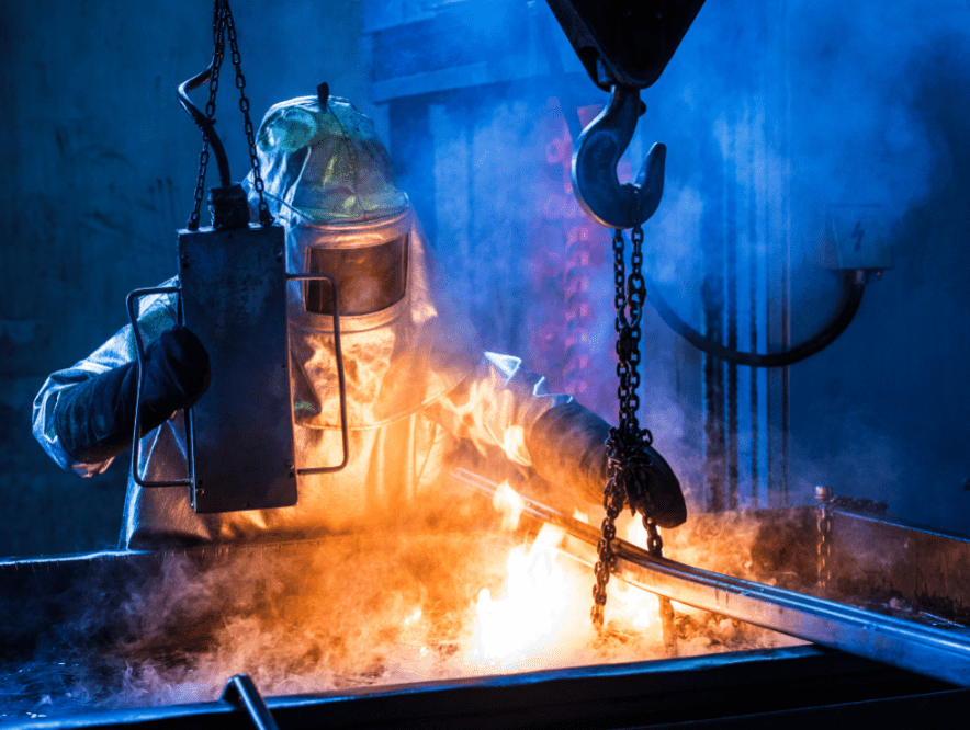 metalworker quenching casts in an oil bath