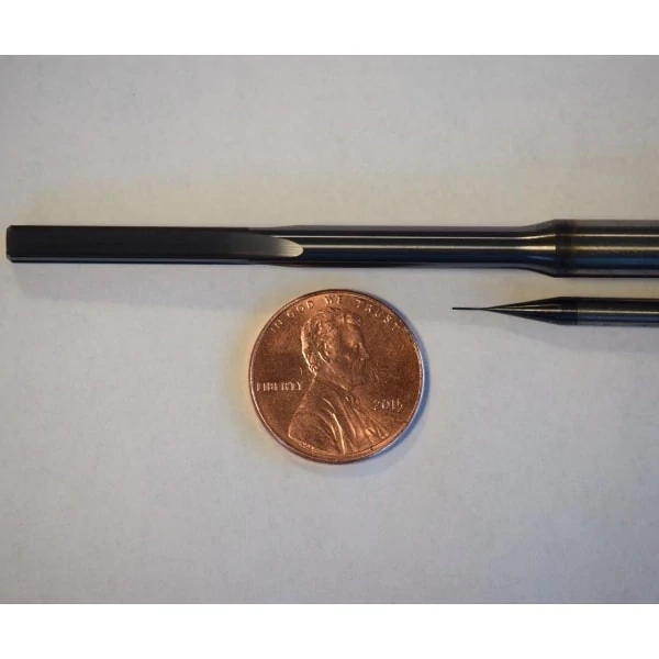 miniature reamer and end mill next to a penny