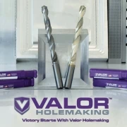 valor cnc drills in front of aluminum and steel blocks with logo beneath